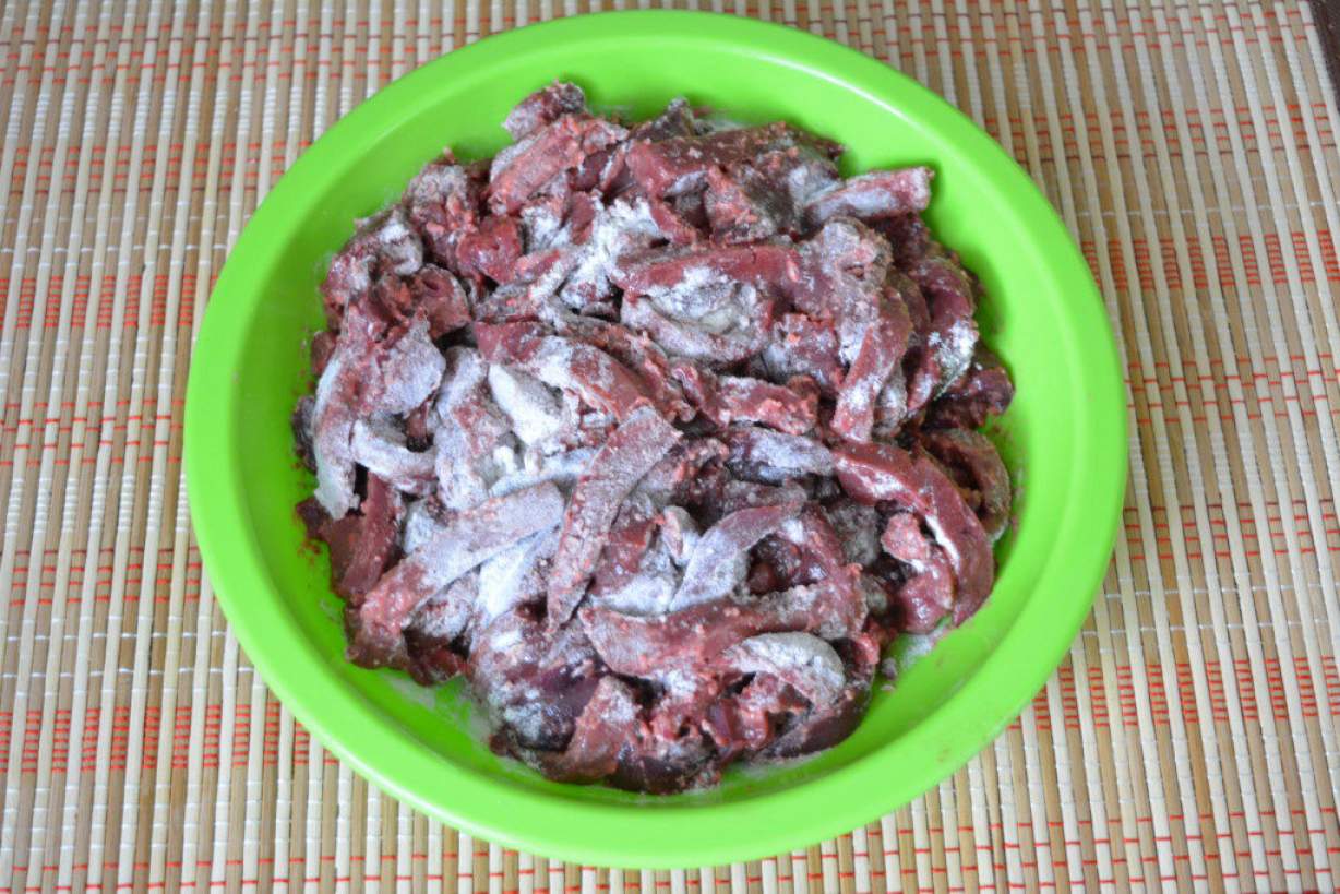 Свиняча печінка тушкована з цибулею і томатною пастою на сковороді