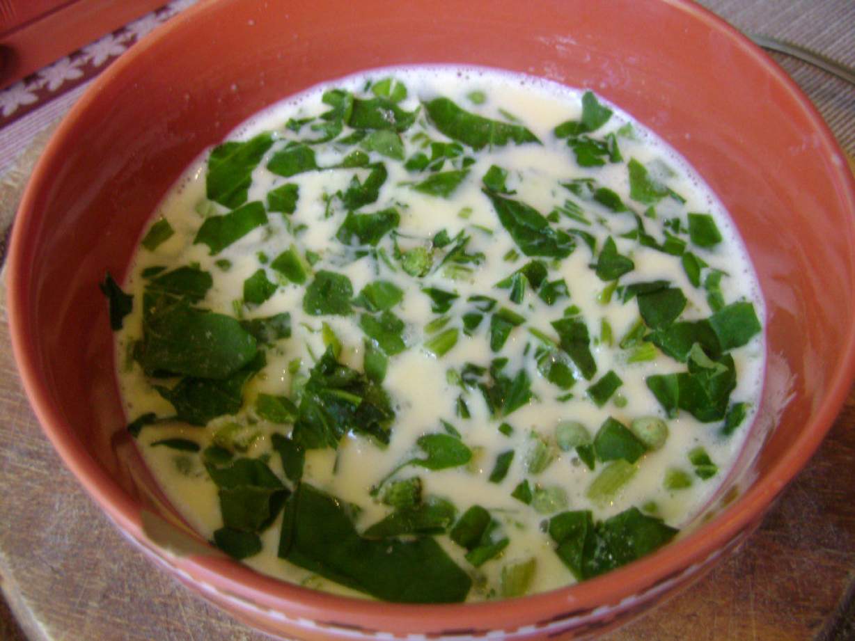 Пишний омлет на сковороді з зеленим горошком і шпинатом