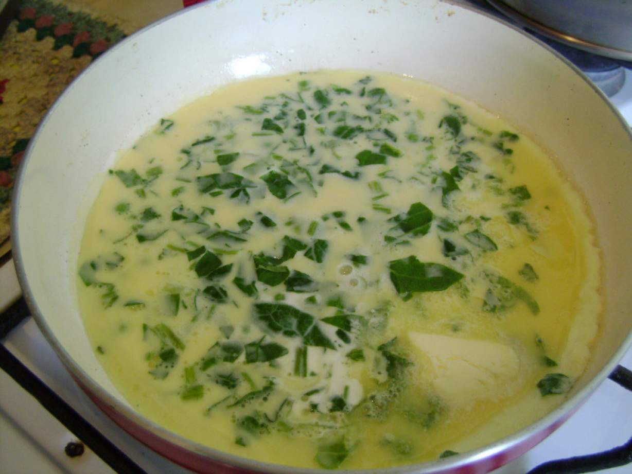 Пишний омлет на сковороді з зеленим горошком і шпинатом